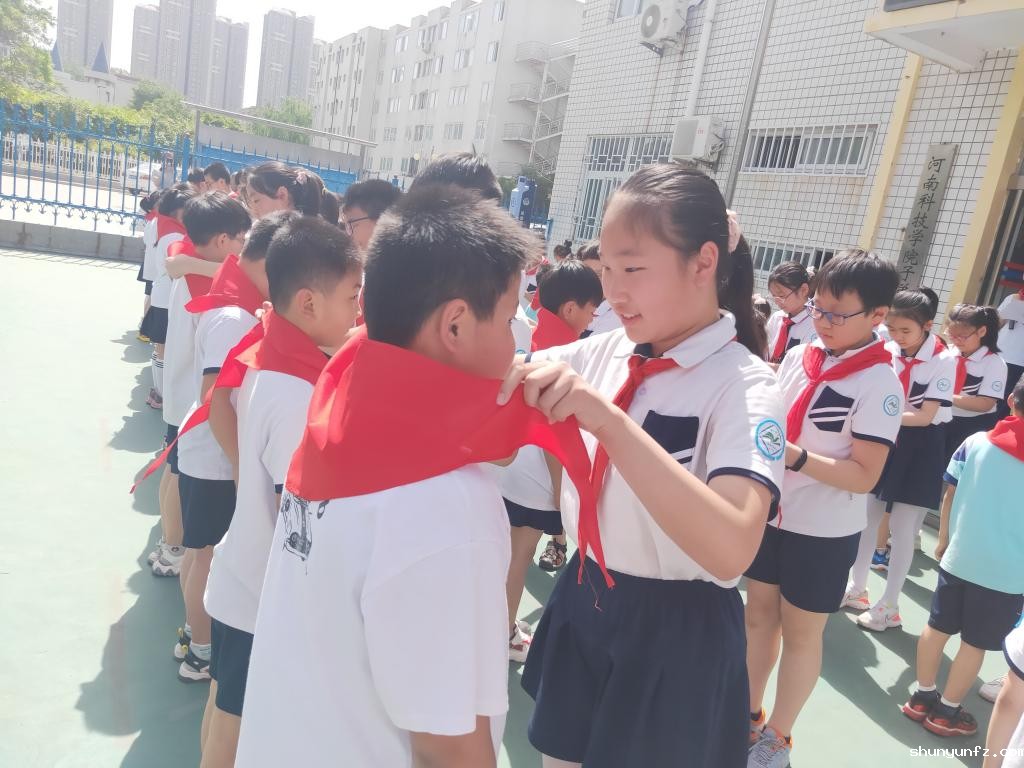 老队员为新队员佩戴红领巾